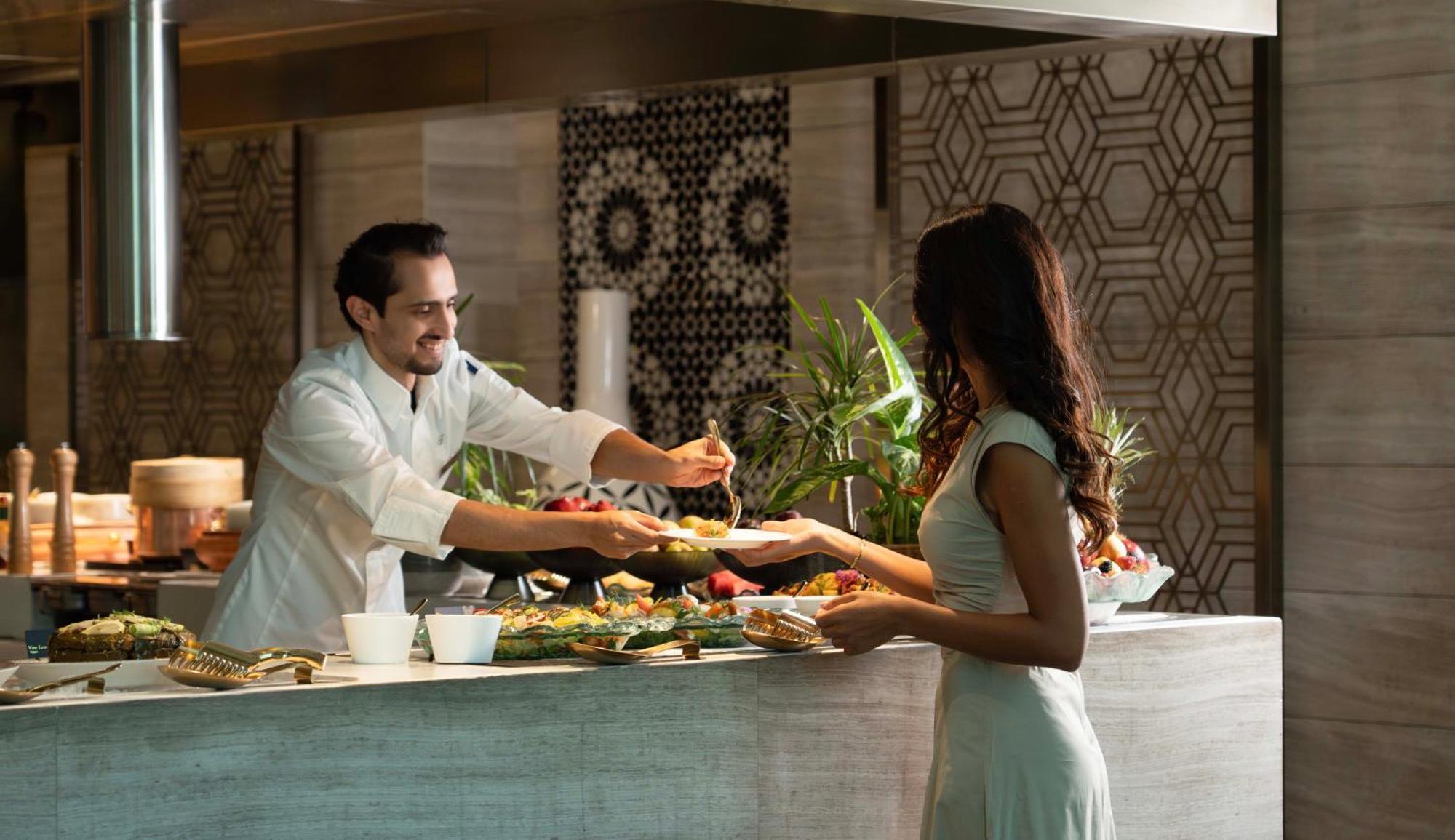 Fairmont Riad Exterior foto A chef serving a guest at the buffet